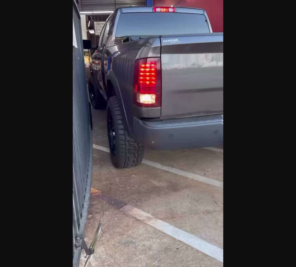 Lifted gray truck with custom wheels and all-terrain tires at Wayside Customz Houston
